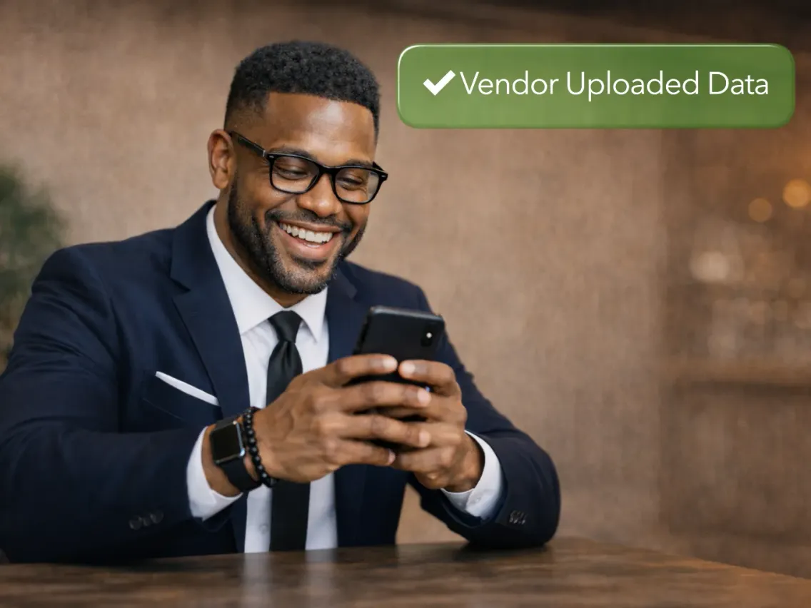 A smiling man in a suit looking at his phone, with a "Vendor Uploaded Data" confirmation